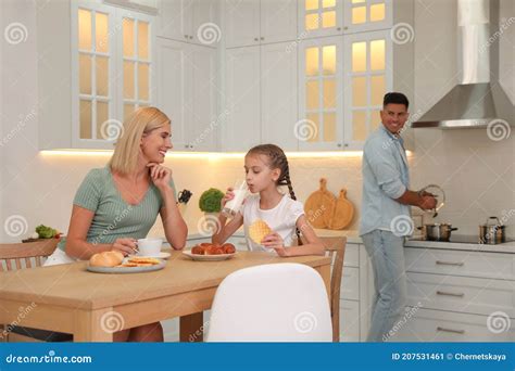 Familia Feliz Comiendo Juntos En Cocina Moderna Imagen De Archivo