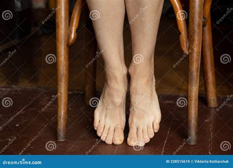 Girl Sitting On A Chair With Bare Feet On An Old Wooden Floor Feet On