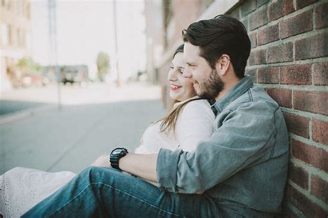 «couple Sitting Down And Laughing And Hugging Del Colaborador De