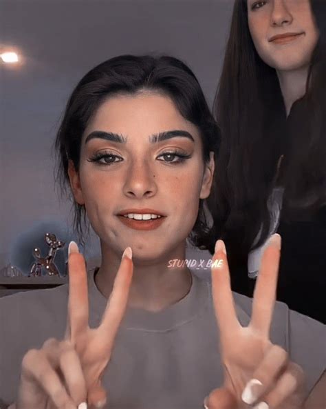 Two Women Are Making The Peace Sign With Their Hands While One Woman Is