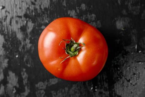 Tomate Rojo Jugoso Sobre Un Fondo Oscuro Foto Premium