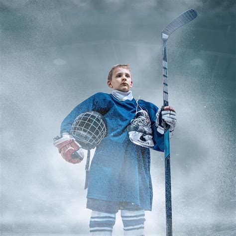 Líder pequeño jugador de hockey con el palo en la cancha de hielo y