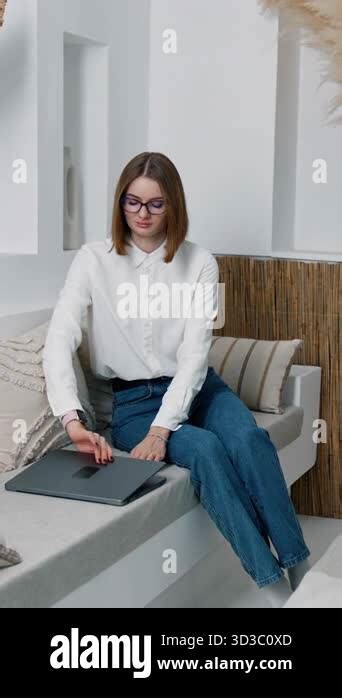 Brunette Woman Sitting On The Sofa Opens Her Laptop Lady Takes The Gadget On Her Laps And