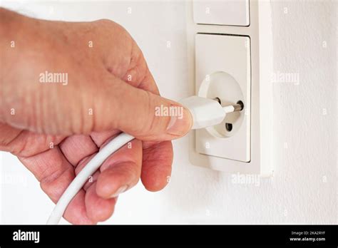 Electrical Cord Plugged Into Wall Outlet Closeup Stock