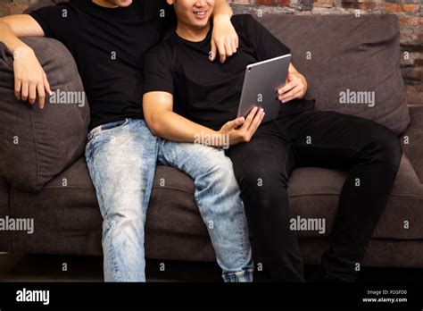 Gay Couple Watching And Looking At Phone Tablet Together Portrait Of Happy Gay Men Homosexual