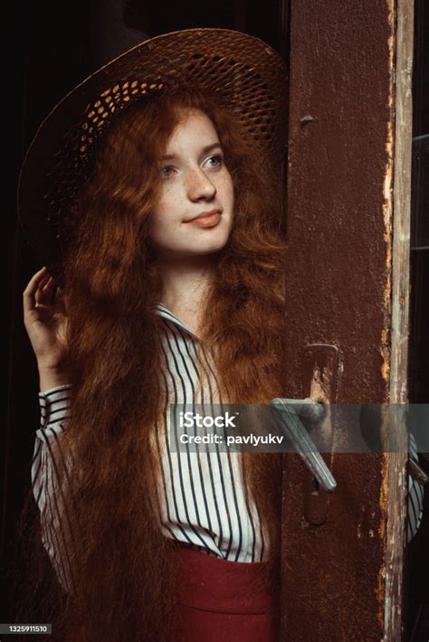 Elegant Young Red Haired Model With Freckles In Straw Hat Posing Near