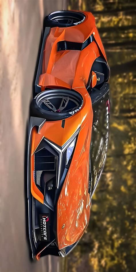 An Orange Sports Car Driving Down A Road Next To A Body Of Water With