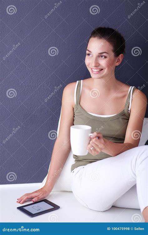 Attractive Caucasian Girl Sitting On Floor With Cup And Tablet Near