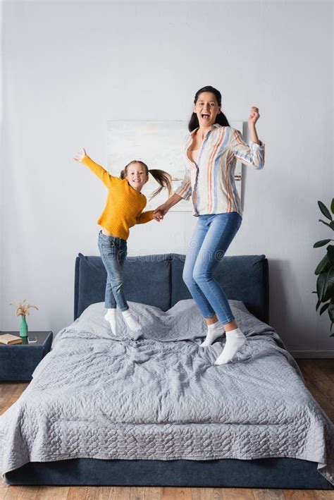 Mother And Daughter Jumping On Bed Stock Image Image Of Attractive