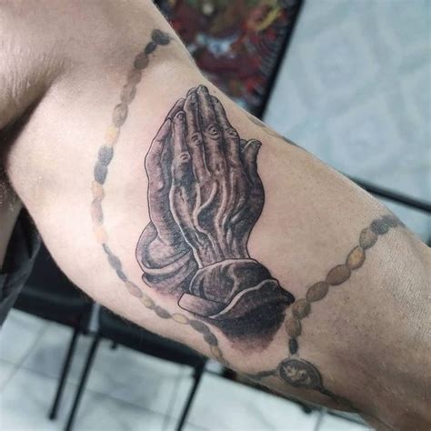 A Man S Arm With A Praying Hand Tattoo On It