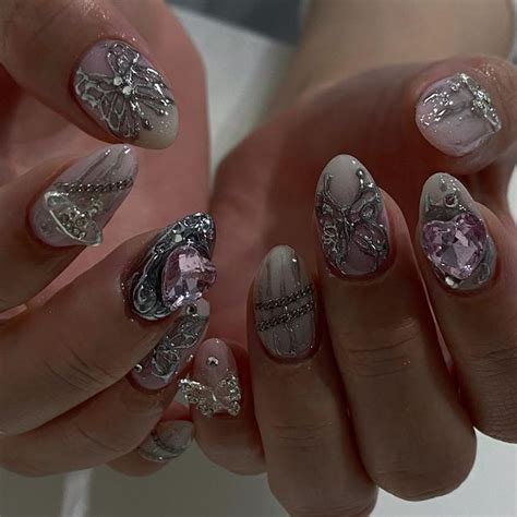 A Woman S Hands With Some Fancy Nail Art On Them Holding Onto Her Nails