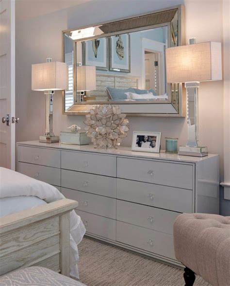 A Bedroom With A Bed Dresser And Mirror On The Wall In Front Of It