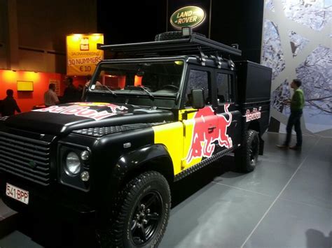 A Black And Yellow Vehicle With Red Bull Painted On It S Side In A Showroom