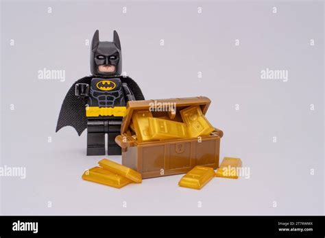 A Lego Batman Minifigure In Front Of Yellow Lego Pieces Resembling Gold