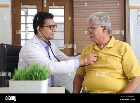 Young Doctor Sitting With Senior Patient In The Doctors Office