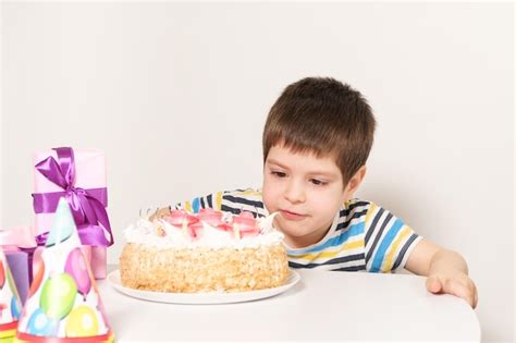 El cumpleañero sopla las velas del pastel de cumpleaños Foto Premium