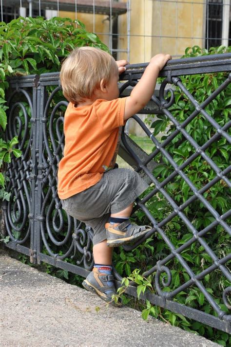 Child climbing fence stock image. Image of over, clever - 15611011