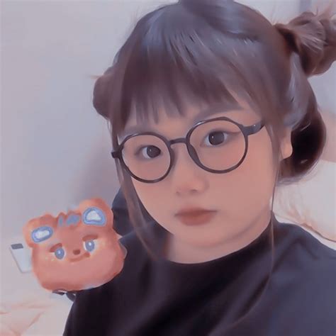 A Girl With Glasses Is Holding A Piggy Bank