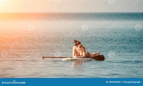 Silueta De Una Feliz Mujer De Mediana Edad Curtida En Bikini Arco Iris Navegando En Sup Board