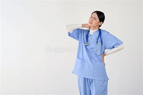 A Tired And Overworked Asian Female Doctor Rubbing Or Massaging Her