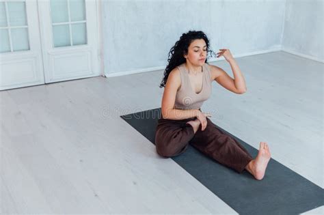 Brunette Woman Doing Gymnastics Yoga Asana On The Floor Stock Photo