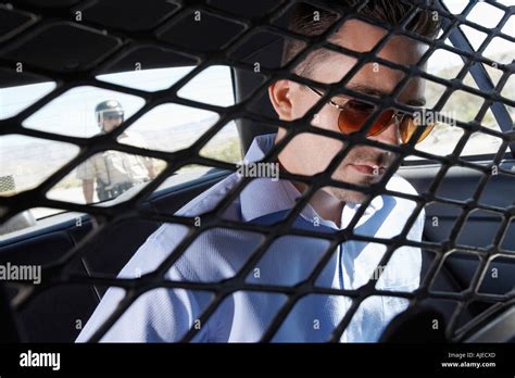 Arrested Man Sitting In Back Of Police Car Stock Photo Alamy