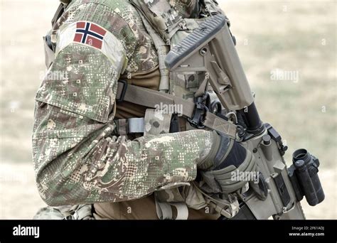 Soldier with assault rifle and flag of Norway on military uniform ...