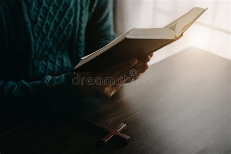 Close Up Of An Open Bible With A Cross For Morning Devotion On A Wooden Table With Window Lights