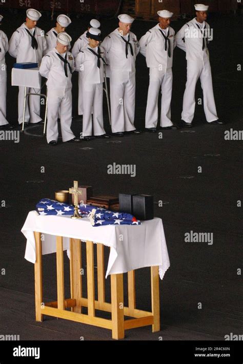 US Navy Sailors bow their heads in prayer during a burial at sea ...