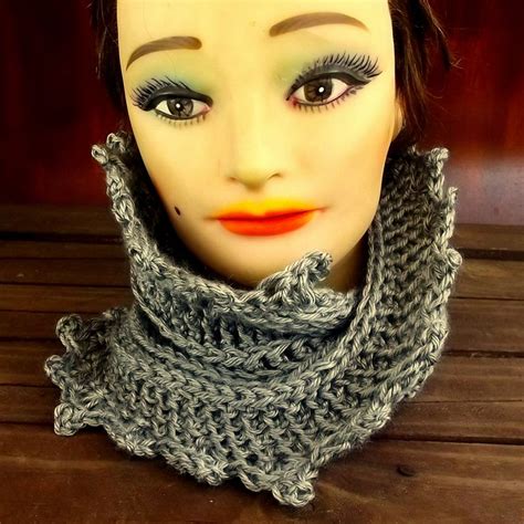 A Mannequin Head Wearing A Gray Knitted Cowl With An Orange Lip