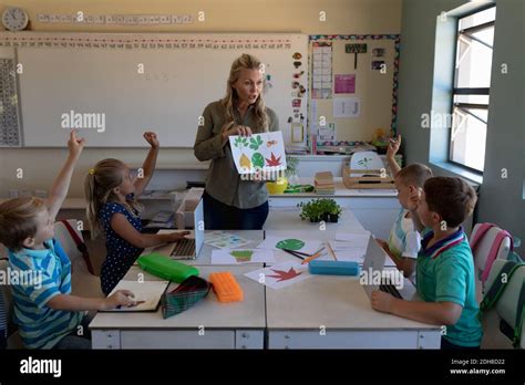 Female Teacher With Long Blonde Hair Standing In A Classroom Stock Photo Alamy