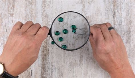 Premium Photo Hand With A Magnifying Glass Looks At The Emerald