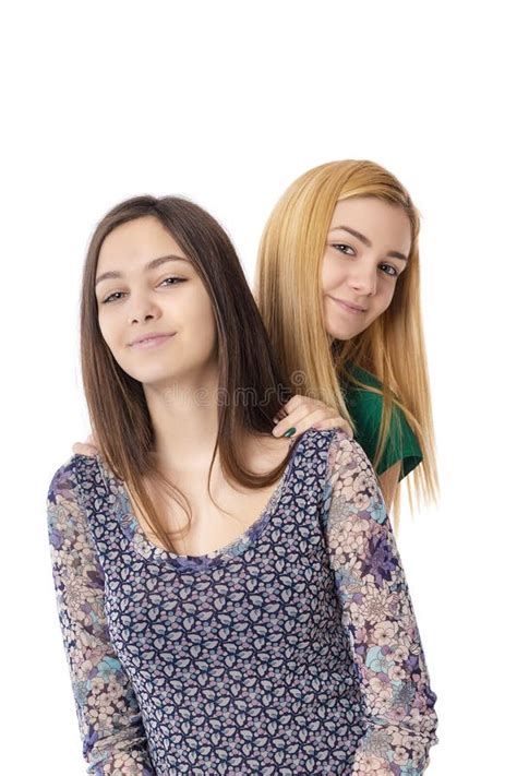 Deux Adolescentes Attirantes De Sourire Blondes Et Brune Pose Image