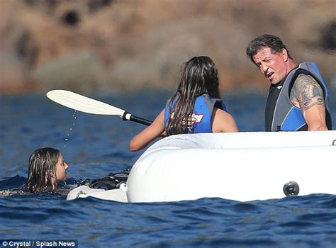 Sylvester Stallone Shows Off His Muscular Torso As He Cheers On His Daughters While They Water