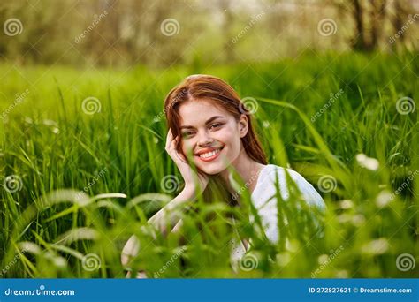 Happy Smiling Redhead Woman Resting Sitting In Tall Grass Stock Image