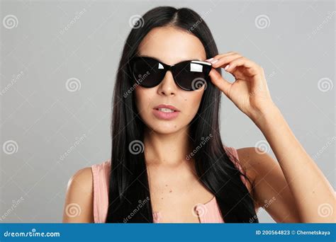 Beautiful Woman Wearing Sunglasses On Grey Background Stock Image Image Of Carefree Posing