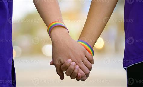 Closeup Hands Which Wear Rainbow Wristband Around Them Of Gay Couple