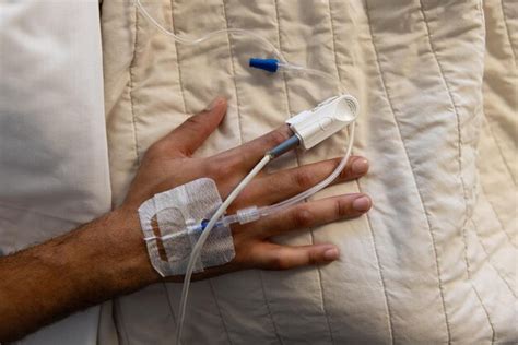 Premium Photo Hand Of Biracial Male Patient With Iv Drip Lying In Bed