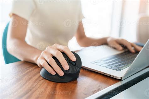 mão de mulher usando mouse ergonômico de computador prevenção de dor