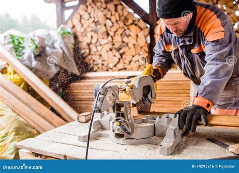 Carpenter Working Man Cutting Plank By Circular Saw Stock Photo