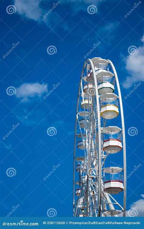 A White Ferris Wheel Against A Blue Sky Background Stock Photo Image