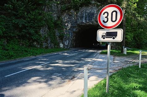 Túnel rocoso de carretera con señal de límite de velocidad 30 en bled