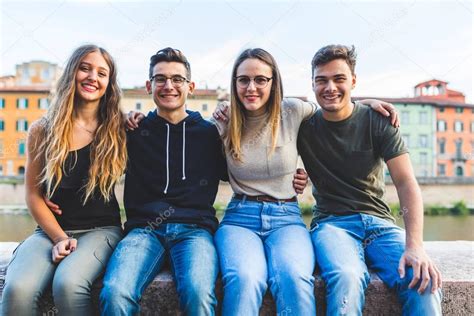 Retrato De Amigos Adolescentes Sentados Juntos En Una Pared De La