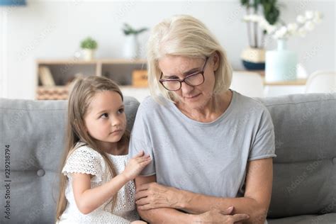 Cute Little Girl Hug Upset Grandmother Feel Sad And Down Comforting Her