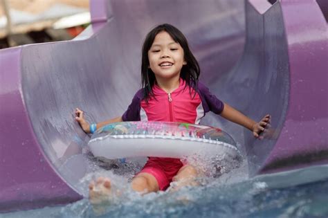 Premium Photo Portrait Of Happy Girl Sliding Down In Water Slide At