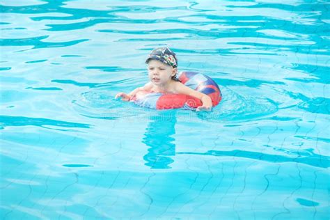 Le Petit Gar On Nage Enfant Gai Sautant Dans La Piscine En Cercle