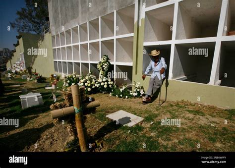 A relative leans on a burial chamber during the graveside ceremony for Eva Melchor, a victim of ...