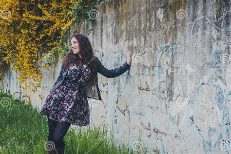 Pretty Girl With Long Hair Leaning Against A Concrete Wall Stock Image