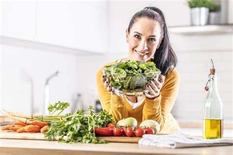 Premium Photo Smiling Woman With A Bowl Full Of Spinach Leaves Along