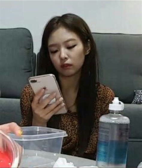 Two Women Sitting At A Table Looking At Their Cell Phones